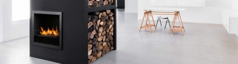 Planika L-Fire in room with log stand